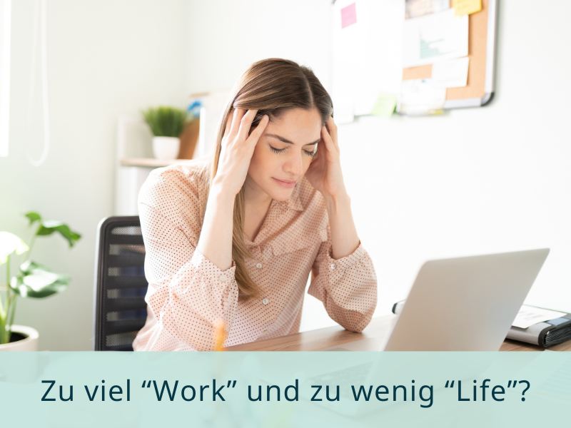 Gestresste Frau am Schreibtisch – Sinnbild für ein Ungleichgewicht zwischen Job und Privatleben